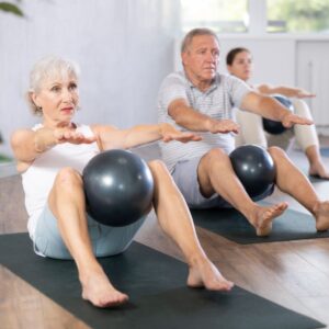 old woman and men exercising using balls for muscle preservation