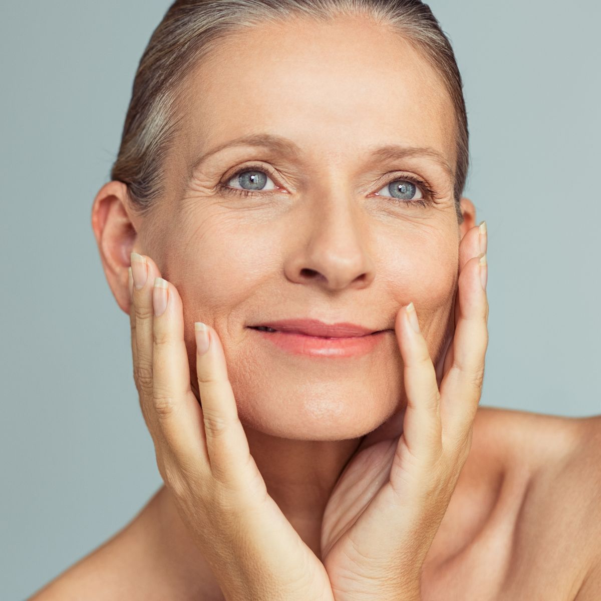 a woman feeling younger touching her skin filled with collagen