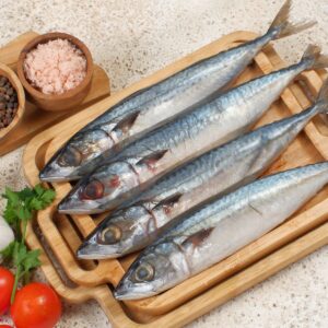 raw sardines in a plate with vegetables