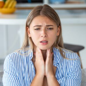 woman holding her neck complaining from thyroid issues