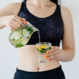 woman serving detox water cucumber lemon fiber hydration constipation tips releif